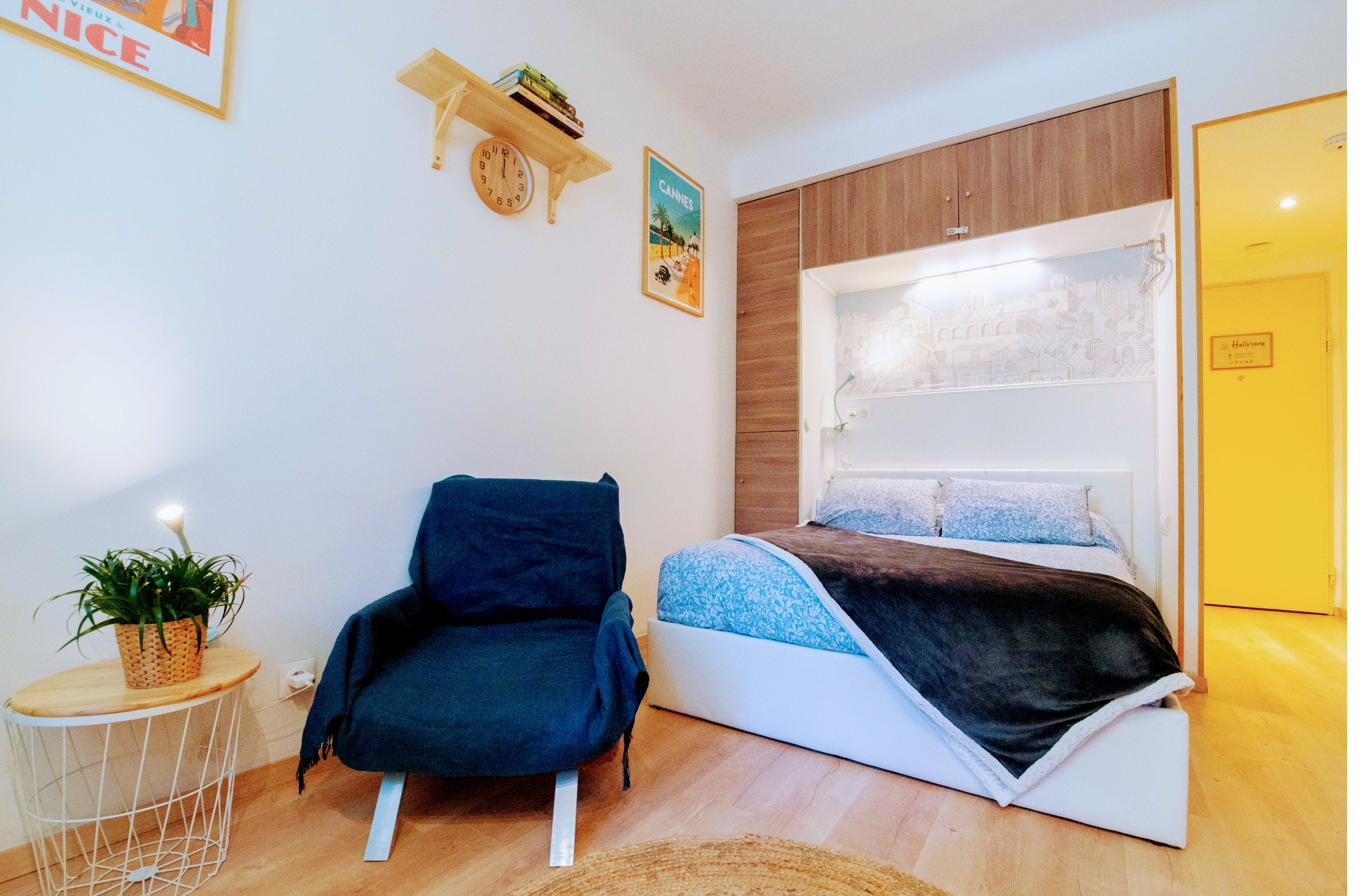 Fauteuil bleu et plante près de la fenêtre