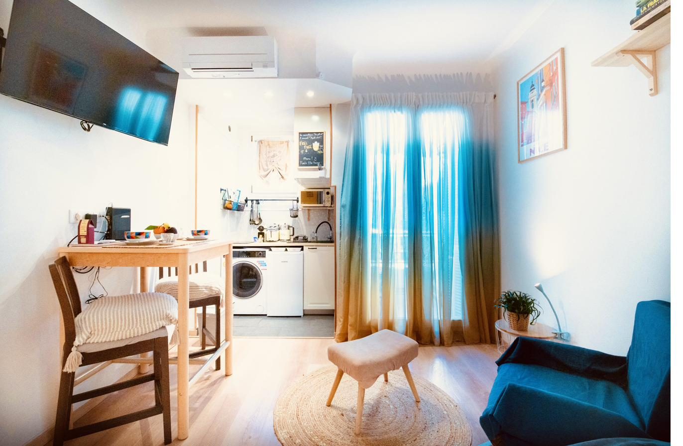 Séjour ouvert sur la kitchenette et rideaux bleu et jaune
